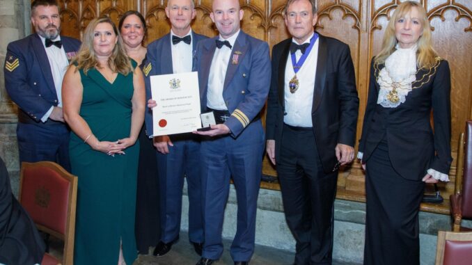OC BBMF, Sqn Ldr Mark ‘Suggs’ Sugden, holds the certificate for the Award of Honour. Left to right: Chief Technician Stu Read, Chief of Staff Flt Lt Emma Phillips, Admin Officer Diane Law-Crookes, Chief Technician Jeff Gullliver, OC BBMF, Capt Jonathan Legat, Master of the Honourable Company of Air Pilots, and Dame Susan Langley DBE, Representative Lord Mayor, City of London.