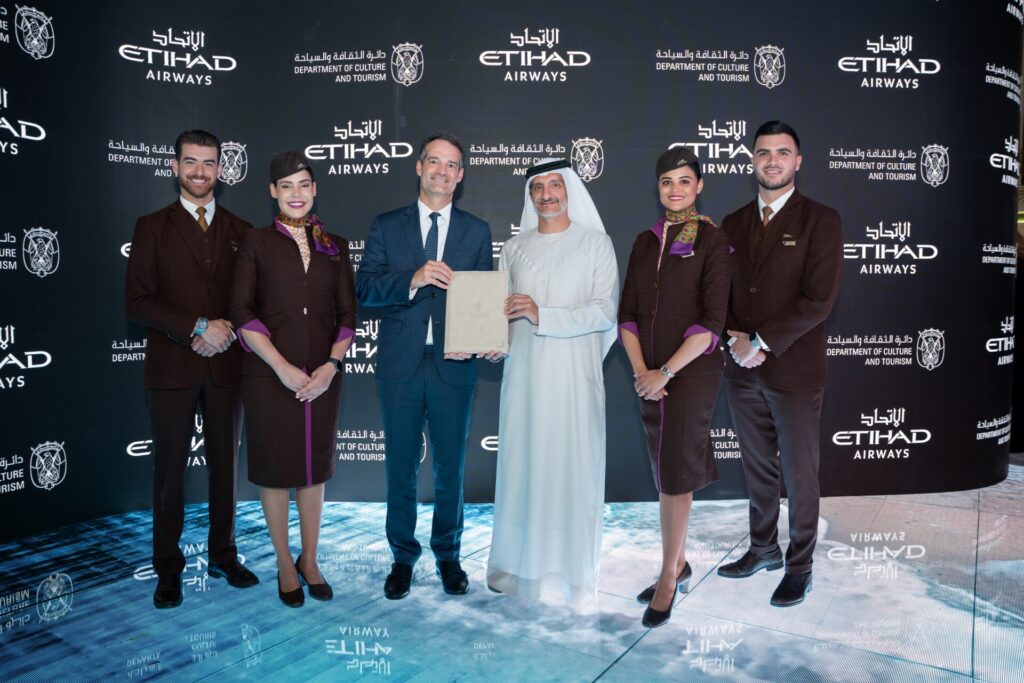 H.E. Saleh Mohamed Al Geziry (centre, right) and Antonoaldo Neves (centre, left) posing with the signed Stopover Abu Dhabi agreement.