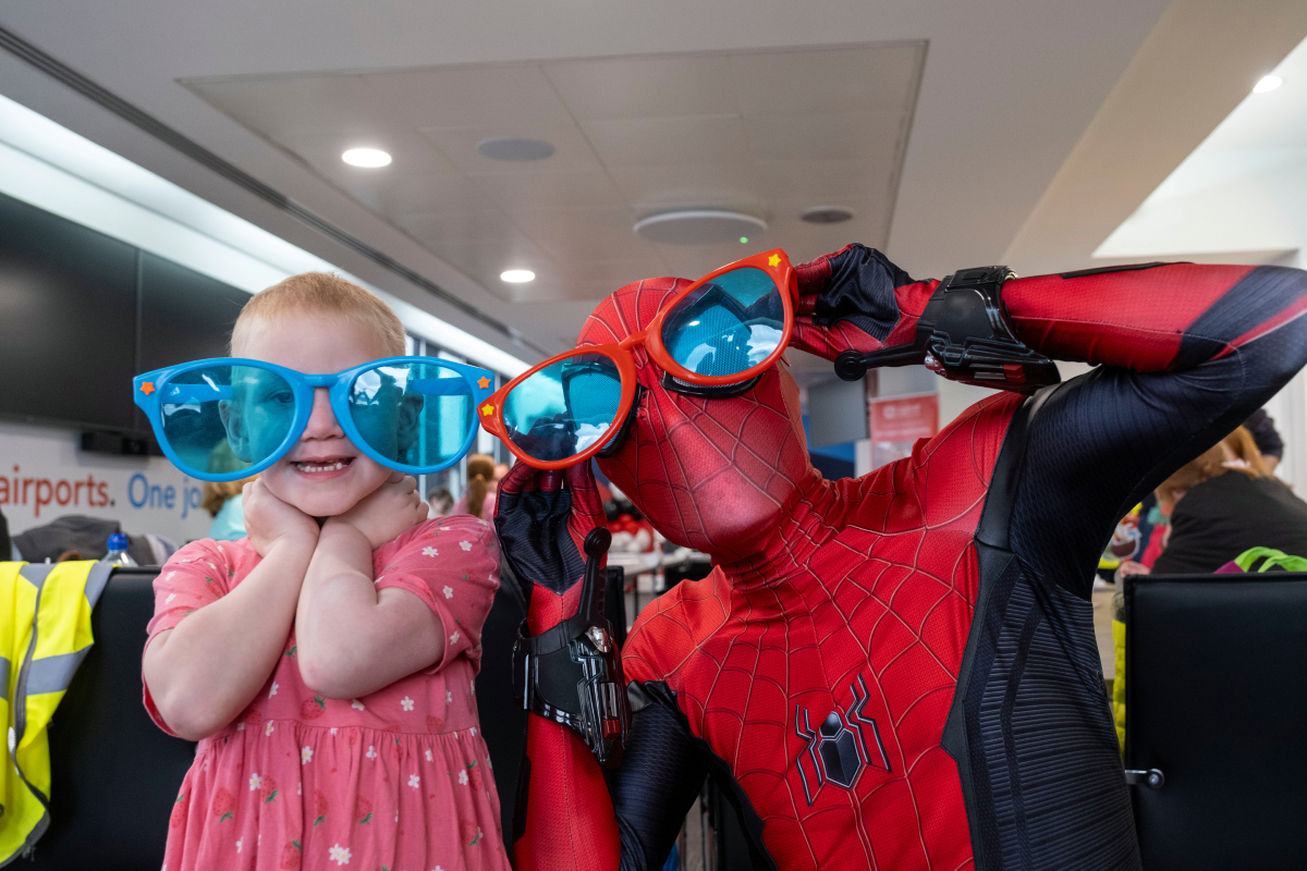 Spider-Man and a child who lives with a life shortening condition in Glasgow Airport's Campsie Lounge