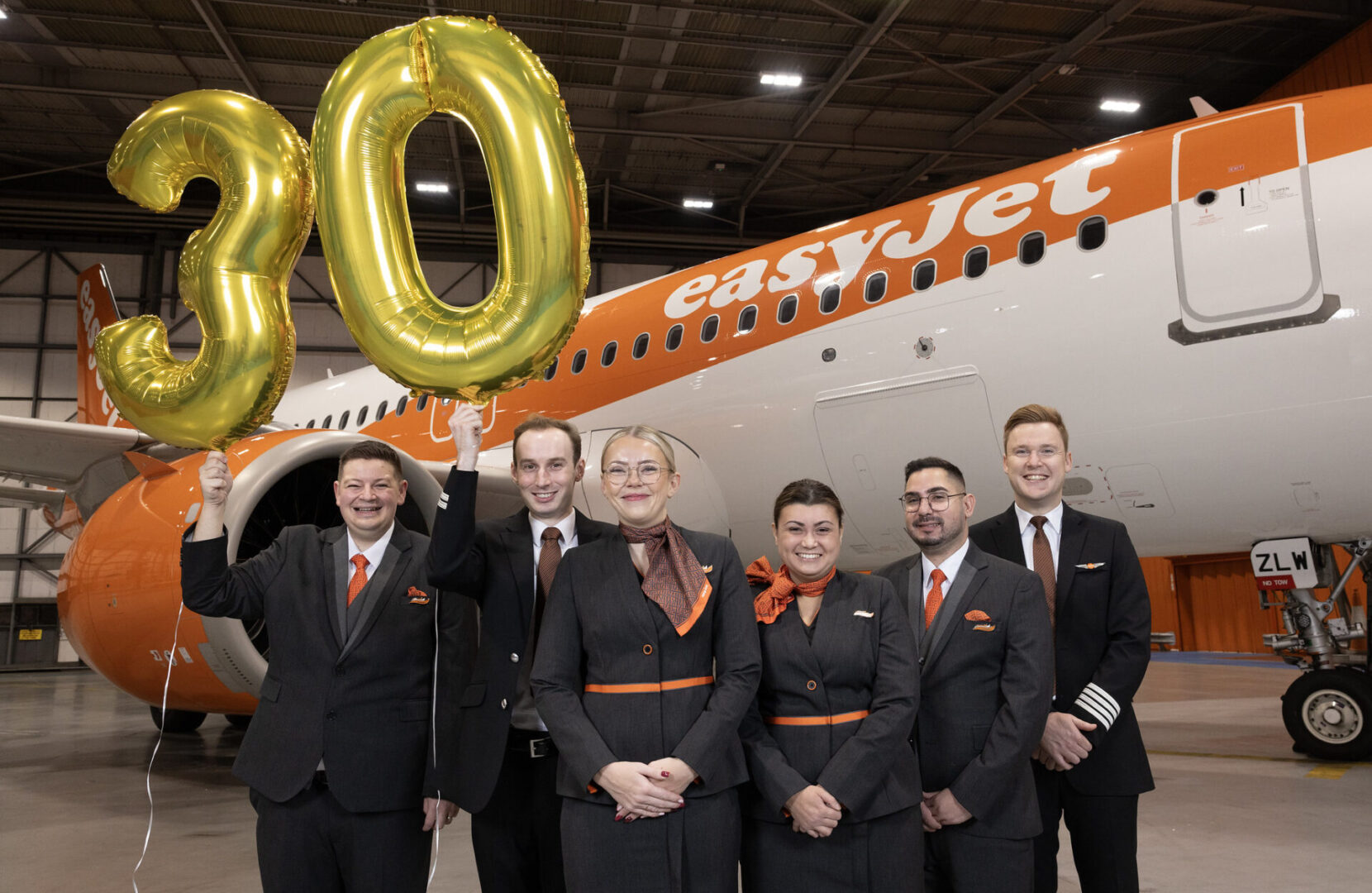 easyJet Cabin Crew L-R - Benjamin Collict, Oliver Spreadbury, Natalie Tavener, Danielle Robinson, Dimo Kolev, Jamie Smart at the easyJet 30th birthday celebrations at London Luton Airport